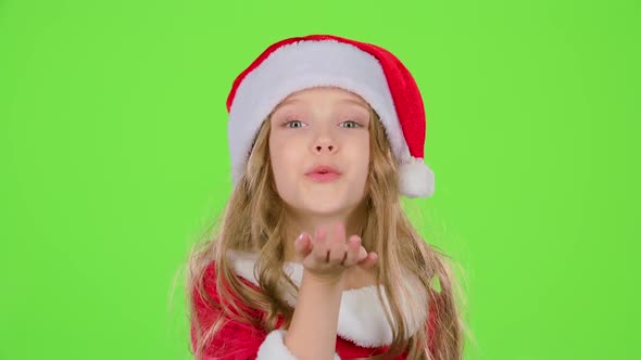 Kid Girl in Red Christmas Caps Send Air Kisses. Green Screen