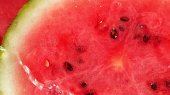 Super Slow Motion Macro Shot of Falling and Splashing Water Drops on Fresh Watermelon at 1000Fps.