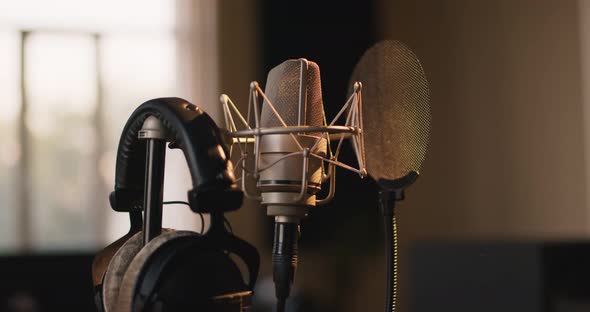 Recording Concept. Tracking Shot of Professional Microphone and Headphones at Sound Record Studio