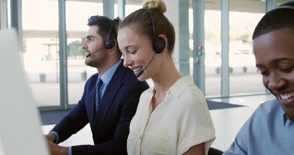 Young business people wearing headsets in a modern office