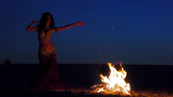 Brunette Dancing Belly Dance Near the Fire, Against a Beautiful Sunset