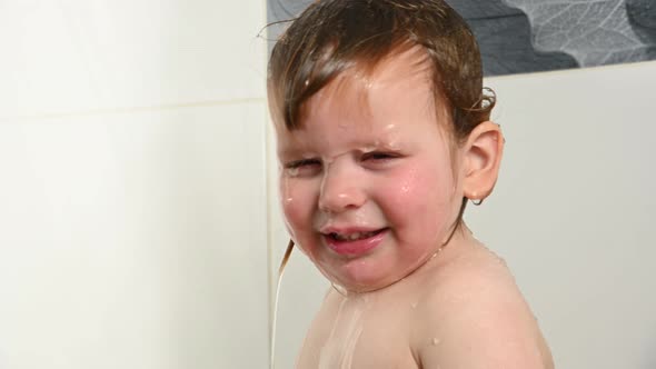 Little boy washing hair in shower water