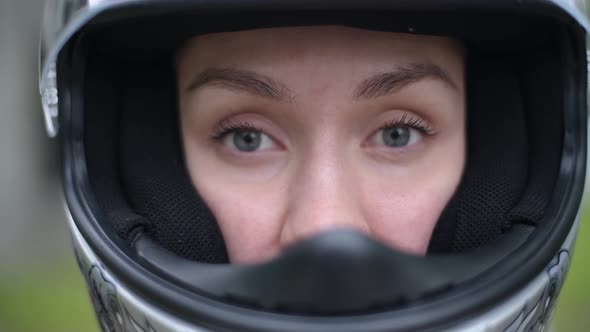 girl looking through the open visor of a helmet