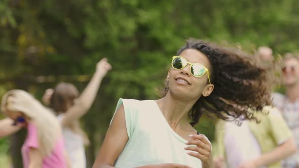 Happy Cheerful Biracial Girl Shaking Hair, Dancing at Outdoor Party With Friends