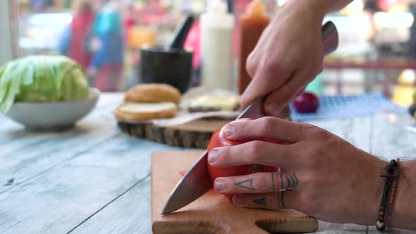 Male Hands Cutting Tomato.