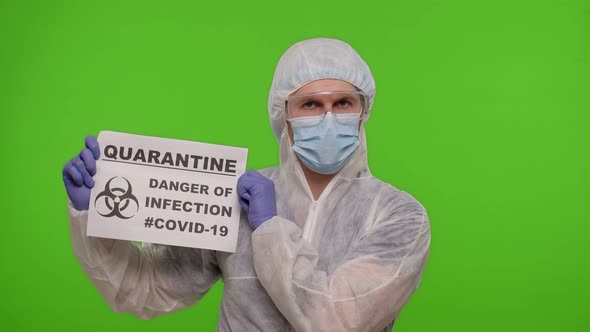 Doctor in PPE Suit Showing Warning Text Slogan on Paper  Quarantine Danger Of Infection Covid19