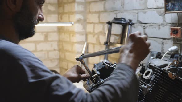 Adult Mechanic Repairing Motor of Motorcycle at Garage