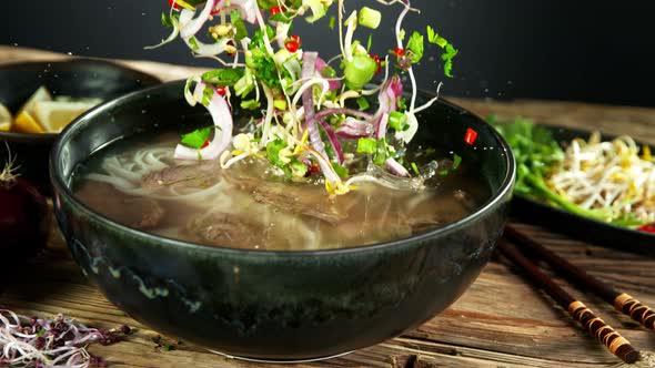 Super Slow Motion Shot of Ingredients Falling Into Beef Pho Soup at 1000 Fps