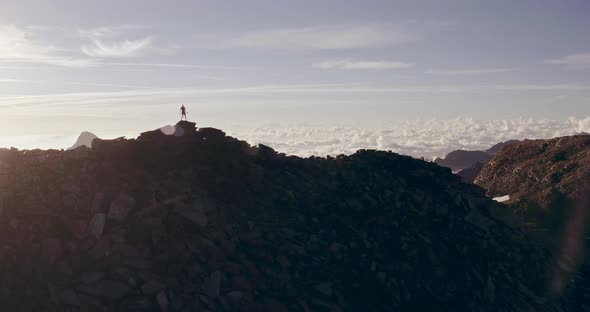 Aerial Trail Runner Man Standing on Mountain Top Peak Goal Looking Horizon View