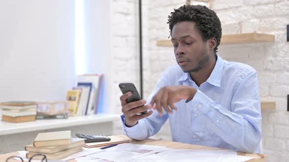 Smart African Man Scrolling on Cellphone