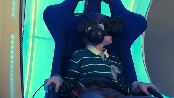 Male Child in Virtual Reality Chair Enjoying His Experience