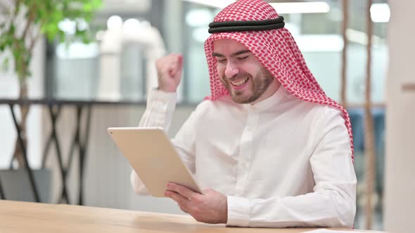 Successful Arab Businessman Celebrating on Tablet in Office