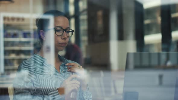 Lady Freelancer Is Seen Through the Window of a Cafe