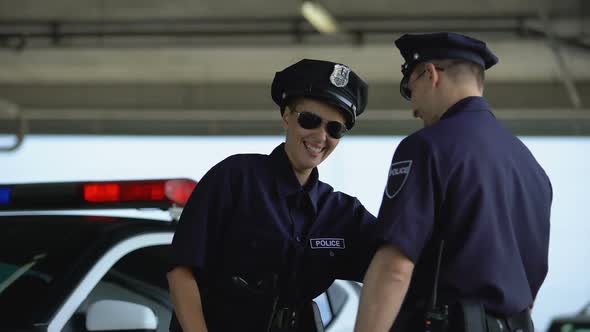 Policewoman Talking to Her Mate and Laughing Standing Near Patrol Car, Break