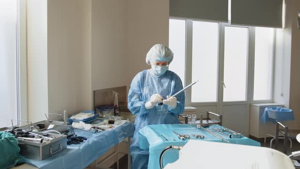 Portrait of Female Medical Worker in Protective Mask Preparing for Surgery