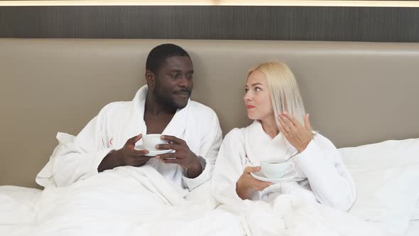 Funny Couple Drinking Tea on Bed