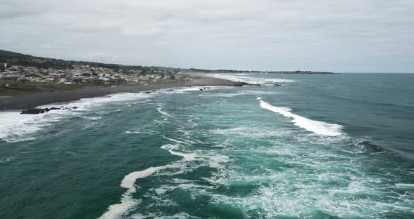 Aerial view of the waves of pichilemu on a cloudy day.