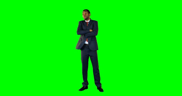 Tensed businessman standing against green background