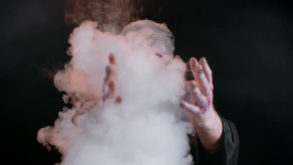 Sinister Man with Horrible Scary Halloween Zombie Makeup in Costume Blows Smoke From Nose and Mouth