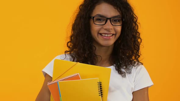 Smart College Student in Eyeglasses Holding Books Yellow Background, Education