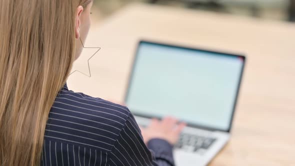 Rear View of Businesswoman Working on Laptop