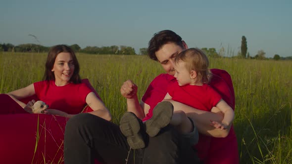 Joyful Parents and Child Bonding Outdoors at Sundown