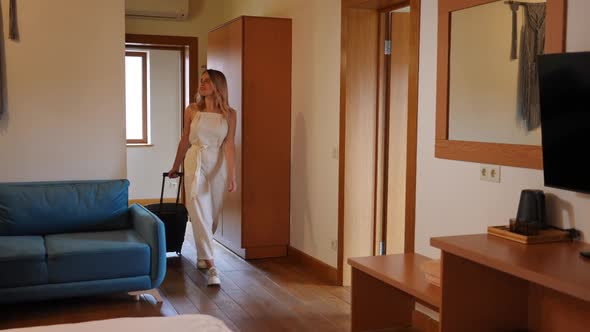 Wide Shot Hotel Room with Young Confident Caucasian Woman Passing with Travel Bag in Slow Motion