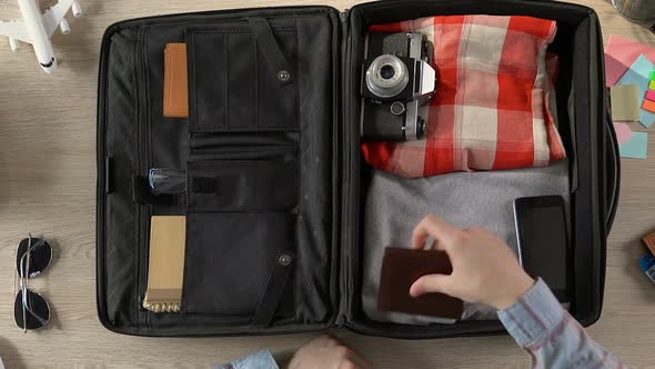 Traveler Packing His Suitcase, Putting Purse, Passport With Tickets and Money