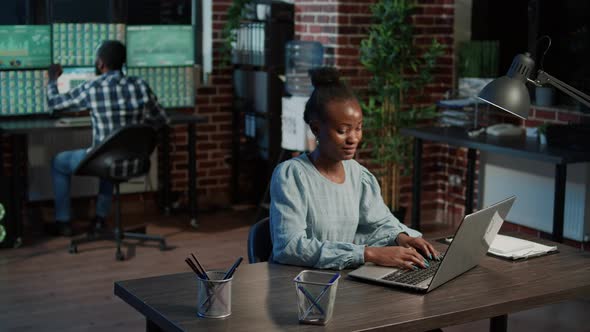 Female Bank Employee Using Laptop to Plan Forex Trade Strategy