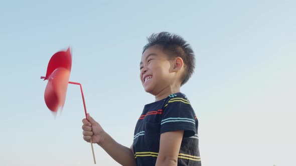 Asian child boy playing with pinwheels