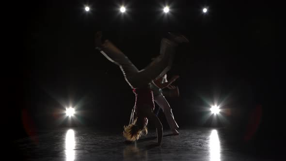 Two Woman Are Practicing Capoeira in Darkness Against Spotlight