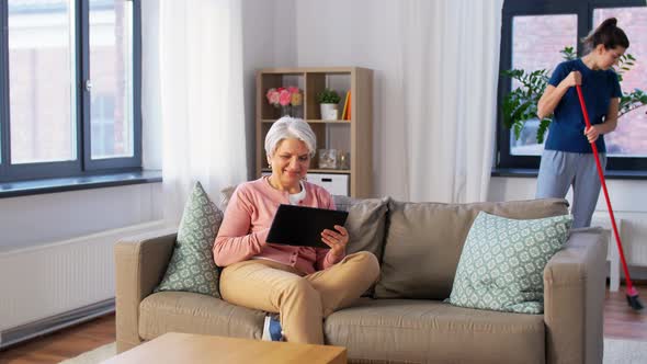 Old Woman with Tablet Pc and Housekeeper at Home