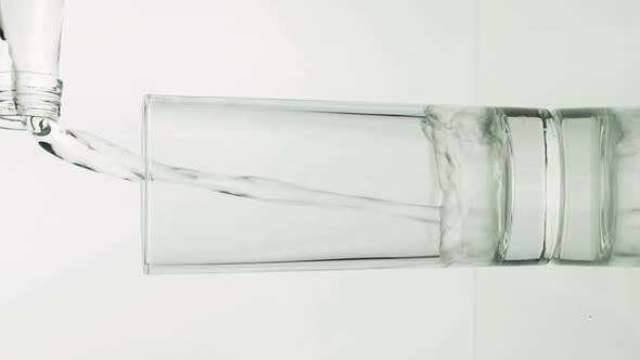 Vertical Video Water is Pouring From Bottle Into Glass