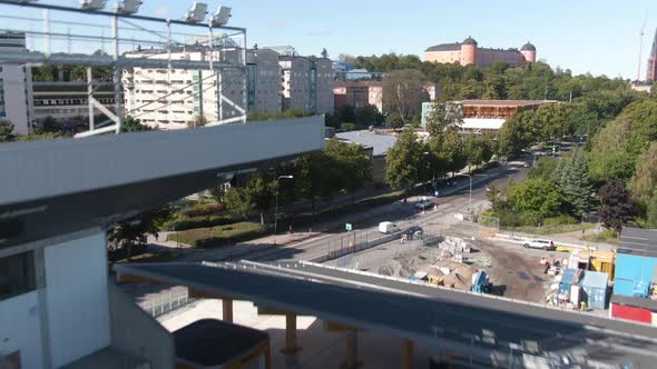 Drone flying over Studenternas Uppsala stadium and rising to cityscape view, Sweden. Aerial forward