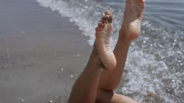 Closeup Woman Legs Waving in Front Ocean Waves Sunny Day