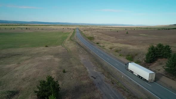 Aerial View of an Intercity Asphalt Road in Rural Area Road Between Fields with Rare Trees
