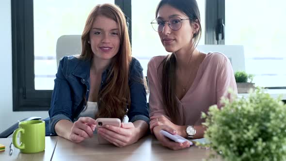 Slow motion shot of businesswomen using smartphone during meeting