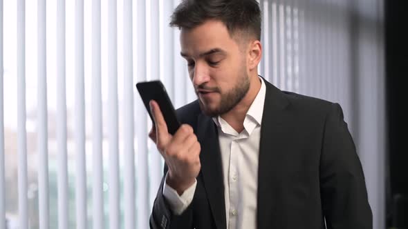 A young male manager or supervisor listens carefully, then yells into the phone