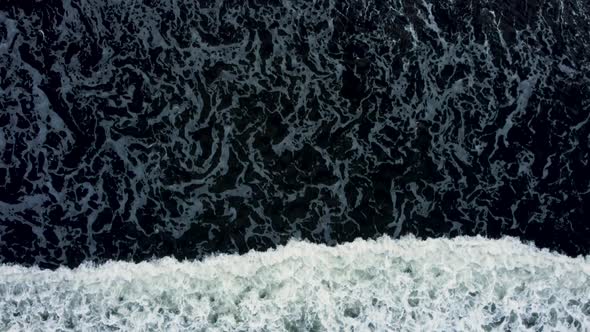 Top down vies waves on the black sand beach