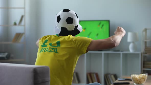 Brazilian Team Supporter Actively Cheering Favourite Football Team Match on Tv