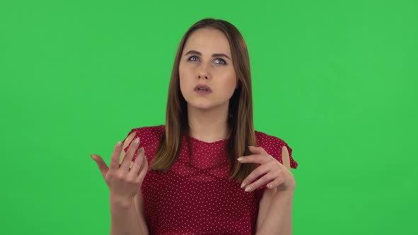 Portrait of Tender Girl in Red Dress Is Focused Thinking About Something, No Idea. Green Screen