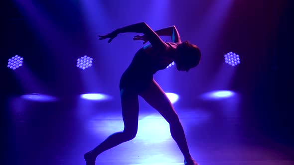 Professional Ballerina in Black Bodysuit Gracefully Dancing Ballet. Shot in Dynamic Spotlights and