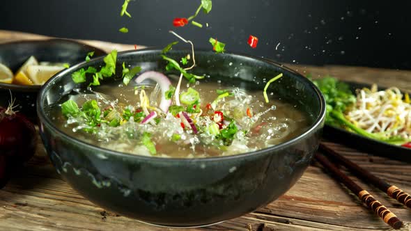 Super Slow Motion Shot of Ingredients Falling Into Vegetable Pho Soup at 1000 Fps