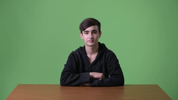 Young Handsome Iranian Teenage Boy Against Green Background