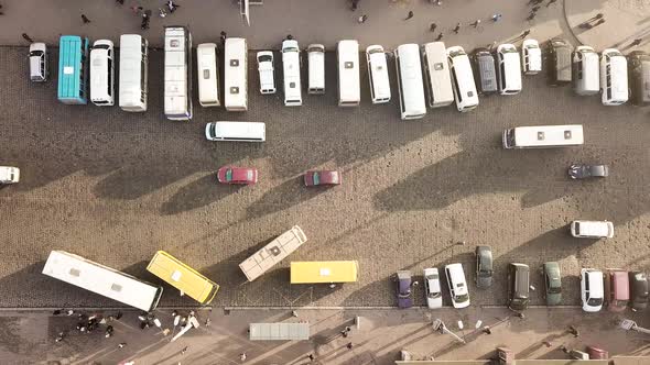 Aerial Footage of Many Cars and Buses Moving on a Busy City Street in Front of Railway Station
