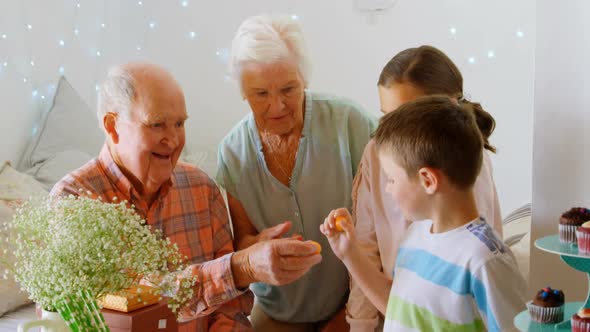 Caucasian grandfather giving chocolate to grandson in a comfortable home 4k