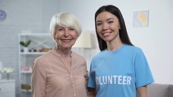 Glad Elderly Female and Volunteer Showing Thumbs Up Smiling on Camera
