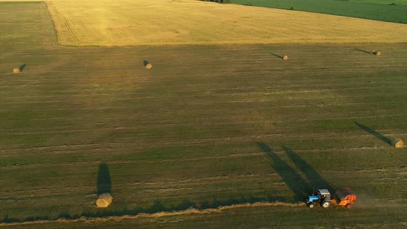 Aerial View Tractor Baling Machine Making Silage Bales on Farmland Cut Wheat