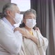 asian retired elderly couple wearing face masks watch the world through their home - VideoHive Item for Sale
