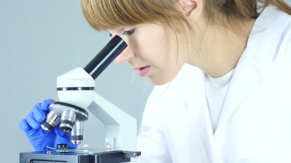 Doctor Using Microscope in Laboratory